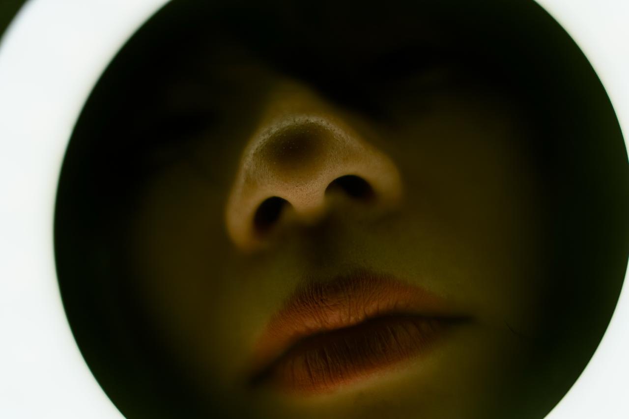 A face lit from below inside a glowing ring