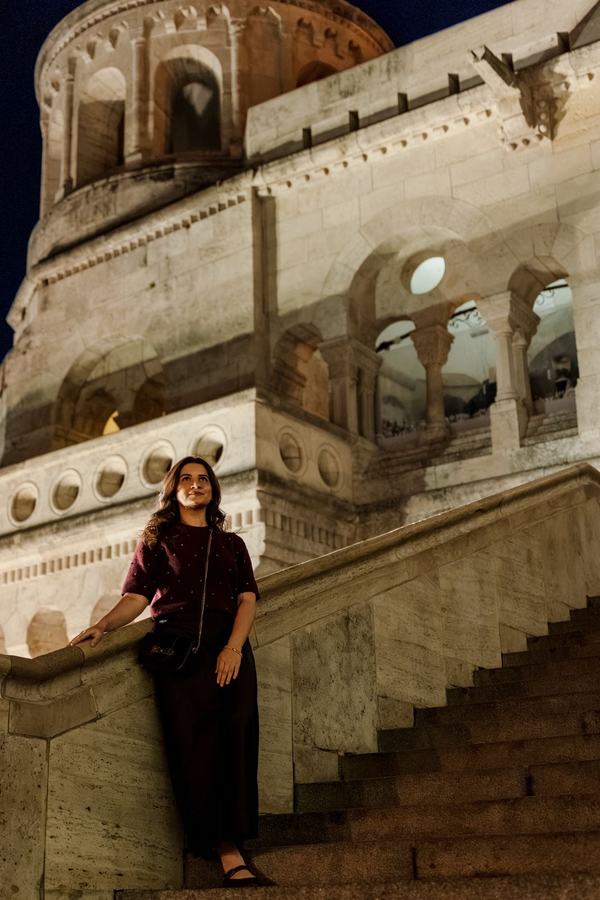 A woman leaning on the stairs of Fisherman's Bastion at night