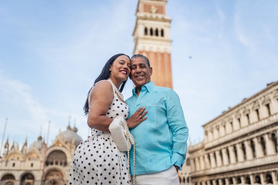 A couple cheek to cheek below the bell tower in St Mark's Square