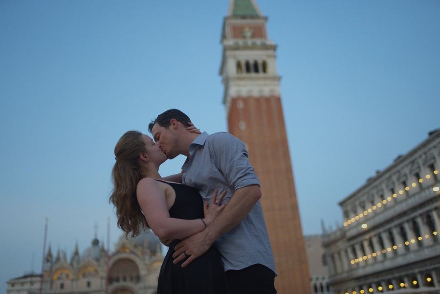 A couple kissing at blue hour below the bell tower of St Mark's
