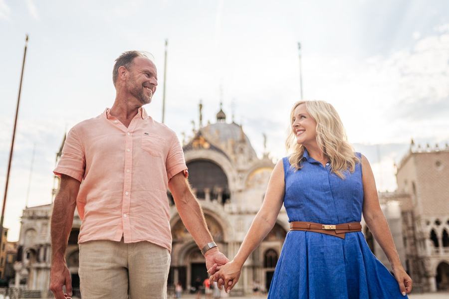 A couple walking hand in hand across St Mark's Square