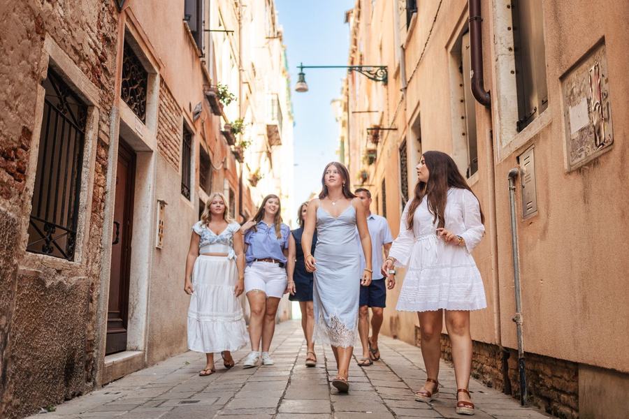 A family walking down a narrow street in Venice